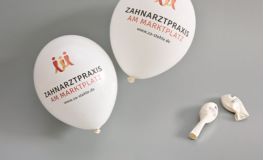 weiße Luftballons mit Corporate Design einer Praxis drauf