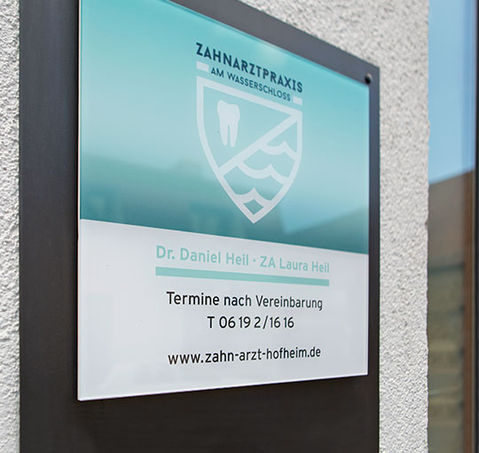 hochwertiges Praxisschild auf der Fassade eines Gebäudes
